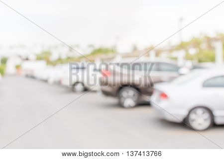 Blurred abstract photo of outdoor car park in countryside background.