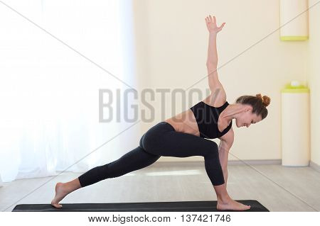 healthy and slim woman Doing Yoga Exercises In White Interior at home.