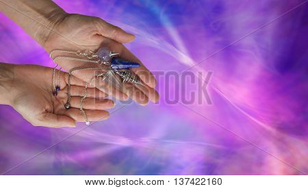 Offering 4 different dowsing pendulums - female dowser holding four radionics pendants in an offering gesture on a vibrant pink and blue energy formation background with copy space