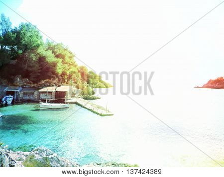Fishing huts on Ibiza Island, Cala Mastella. Idyllic scene with boat huts and fisher boats anchored.