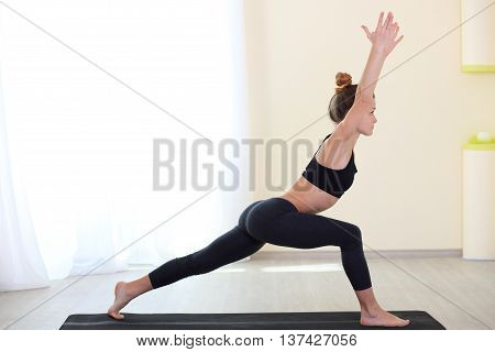 Slim and sporty woman practice Yoga in a training hall background. Healthy lifestyles concept