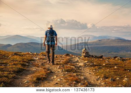 hiker with backpack traveling in Norway mountains Dovre