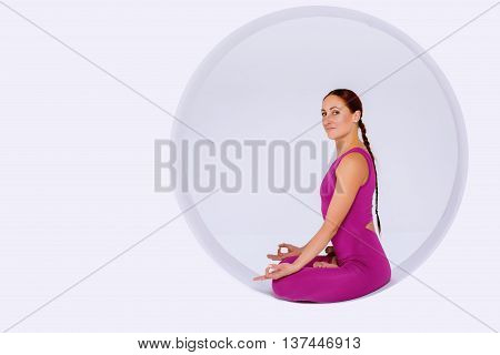 Portrait woman doing yoga exercises in geometric design of round shapes in sphere. Studio shot white background. Creative concept of sports.