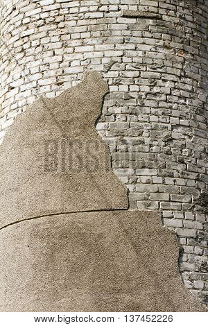 The bricks white and a piece of crumbling plaster. Exterior wall coating.