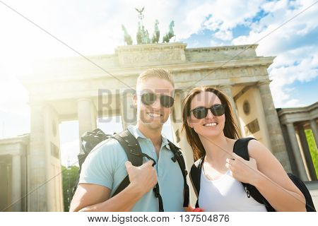 Young Happy Couple Standing In Front Of Brandenburg Gate