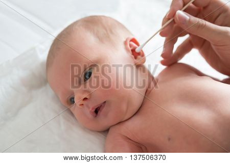 Close-up Of A Mother Cleaning Baby Ear With Swab