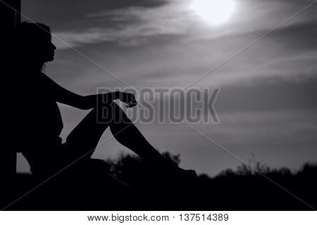Woman silhouette in black and white at sunset