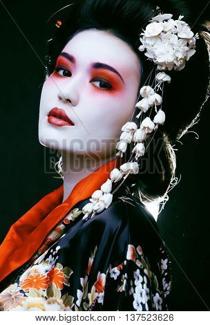 Young beautiful asian woman's portrait, geisha in kimono on black