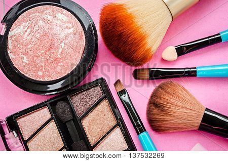 The Various makeup products on pink background.