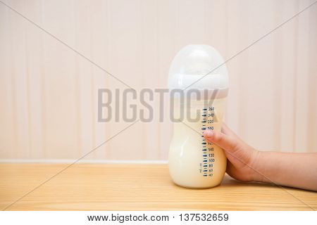 kid getting a baby bottle of powdered milk at home