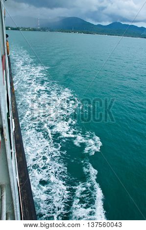 passenger ship water trail leaving form an islan