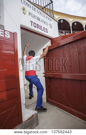 Pozoblanco Spain - September 23 2011: Man opens the bullpens door so that the bull goes out to the bullring of Pozoblanco Cordoba province Spain