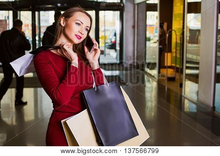 Happy Woman with Shopping Bags in  Mall.telephone. Fashion Shopping lady Portrait. shopping concept.