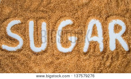 The word sugar written over a pile of brown sugar