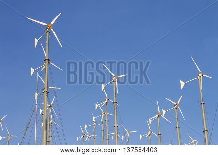 Wind driven generators turbines over blue sky