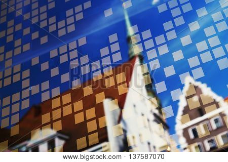 Reflection of the Cathedral of St. Peter and the sky with clouds in the window of the building with a backdrop of silver rectangles in Riga