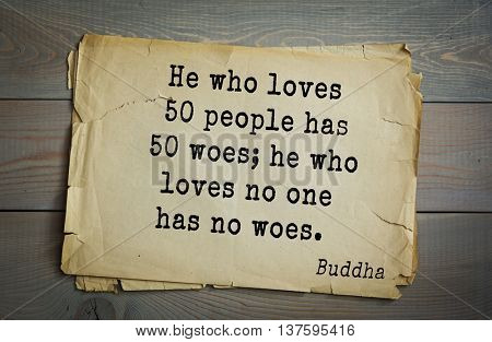 Buddha quote on old paper background. He who loves 50 people has 50 woes; he who loves no one has no woes. 