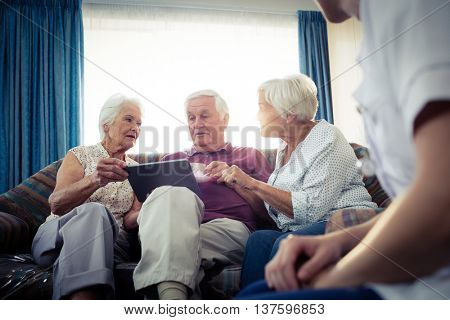 Seniors using a tablet computer in the retirement house
