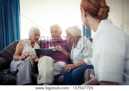 Seniors using a tablet computer in the retirement house