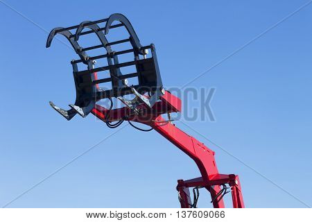 Big red grab of excavator or tractor isolated on white.