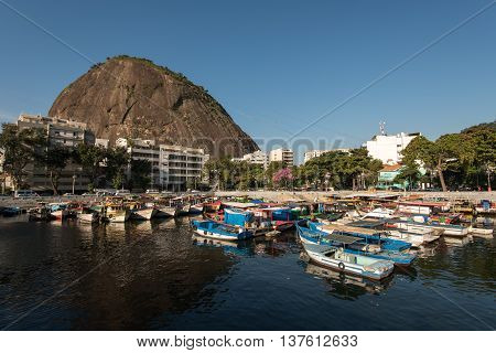 Rio de Janeiro, Brazil - July 4, 2016: Fisherman and passenger boats are docked at the small Urca Square harbor.