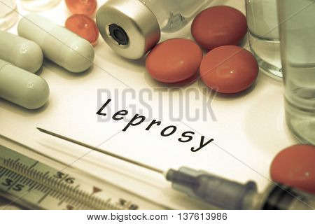 Leprosy - diagnosis written on a white piece of paper. Syringe and vaccine with drugs.