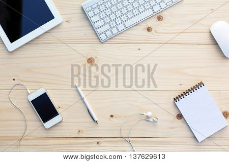 Light wooden Background and modern Business Items on Desk Office Computer Keyboard and Mouse White Pen Tablet PC opened Notepad Earphones dynamic Diagonal alignment
