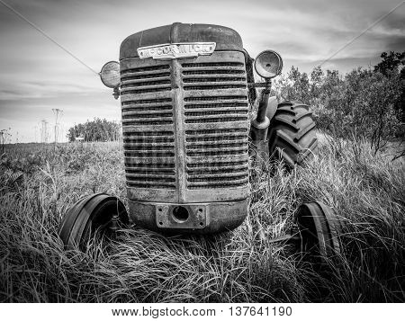 SASKATCHEWAN, CANADA - JUNE 30: An abandoned tractor on June 30, 2016 in field in Saskatchewan, Canada. Saskatchewan is a major agricultural producer in Canada.