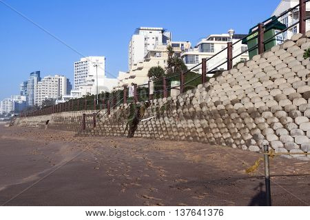 Concrete Retaining Wall  On Empty  Beach  Against City Skyline