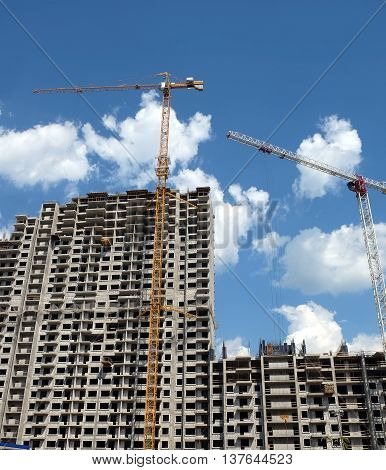 New high-rise modern apartment building construction in process ob bright sunny day front view vertical