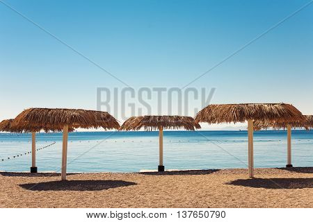 Empty beach with straw umbrellas in Eilat city Israel