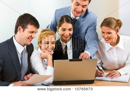 5 若いビジネスマンのグループが一緒に興味深い questi を議論するラップトップ周りを収集