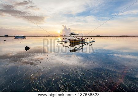 Holiday in Bali, Indonesia - Reflection Sunrise in Tanjong Benoa with boat