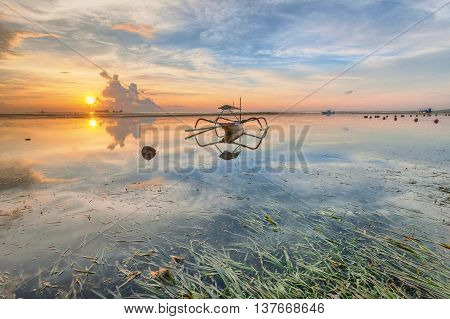 Holiday in Bali, Indonesia - Reflection Sunrise in Tanjong Benoa with boat