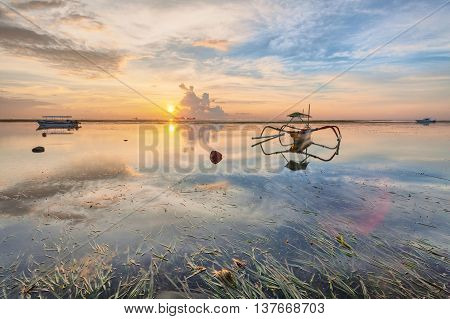Holiday in Bali, Indonesia - Reflection Sunrise in Tanjong Benoa with boat