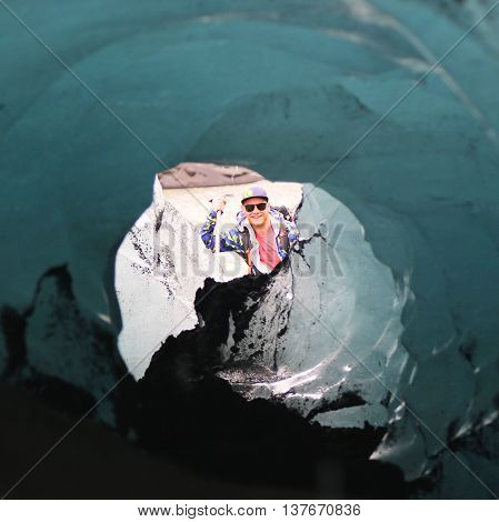 ICELAND - JULY 4, 2016: Tour guide exploring ice cave at Solheimajokull glacier. Solheimajokull glacier is one of the biggest glaciers in Europe