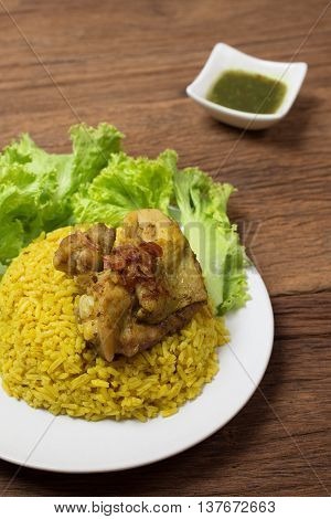 Thai chicken biryani (Khao Mok Gai) or Yellow curry rice Thai Food Style on wood background