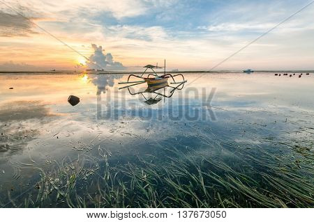 Holiday in Bali, Indonesia - Reflection Sunrise in Tanjong Benoa with boat