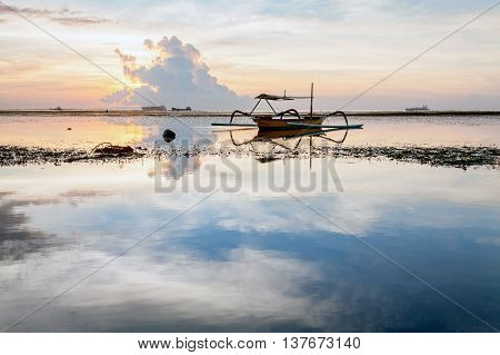 Holiday in Bali, Indonesia - Reflection Sunrise in Tanjong Benoa with boat