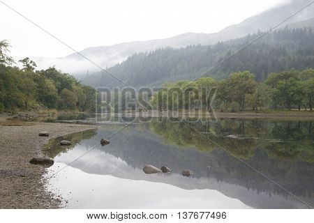 Scottish Loch showing reflections of a misty mountainside