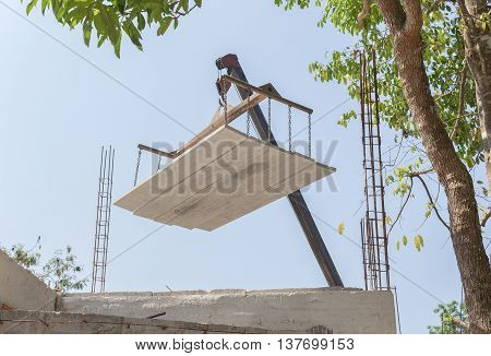 Industrial Crane operating works loading of cement sheet In construction.