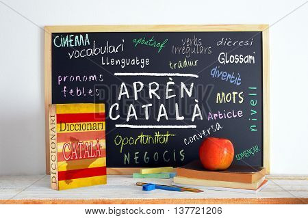 Blackboard in a classroom with the message LEARN CATALAN and some text