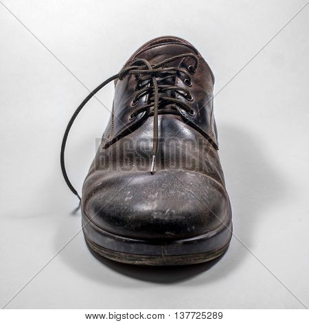 Dirty men's shoes sprinkled with whitewash. Shoes on a white background.