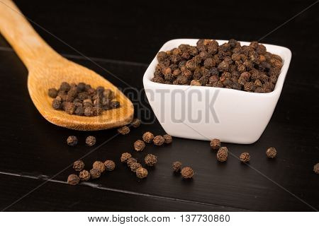 milled black pepper Black pepper corns and Black pepper Powder. White saucers