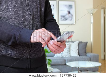 Male using smarphone with background of the room interiors