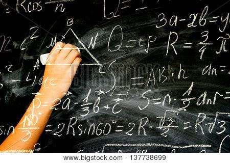 Hand with chalk writting on math formulas black board, double exposure