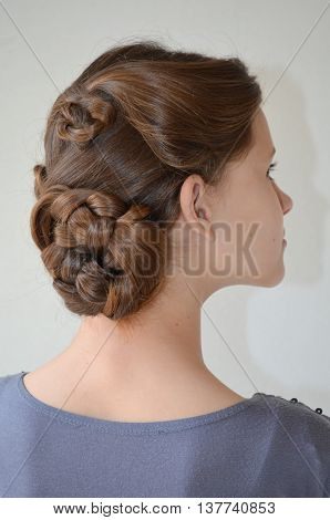 Weaving with long hair - young girl in blue on a white background