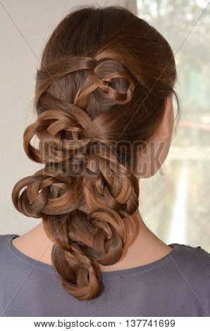 Weaving with long hair - young girl in blue on a white background