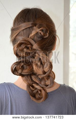 Weaving with long hair - young girl in blue on a white background