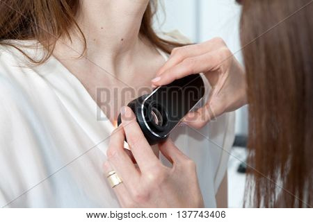 Doctor examining birthmarks and moles on a female patient (examination of birthmarks)